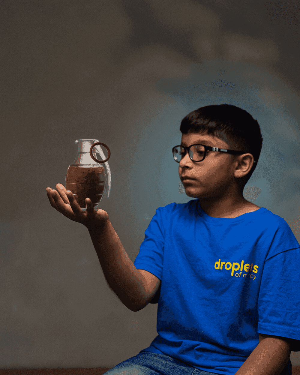 A child holding dirty water shaped like a grenade