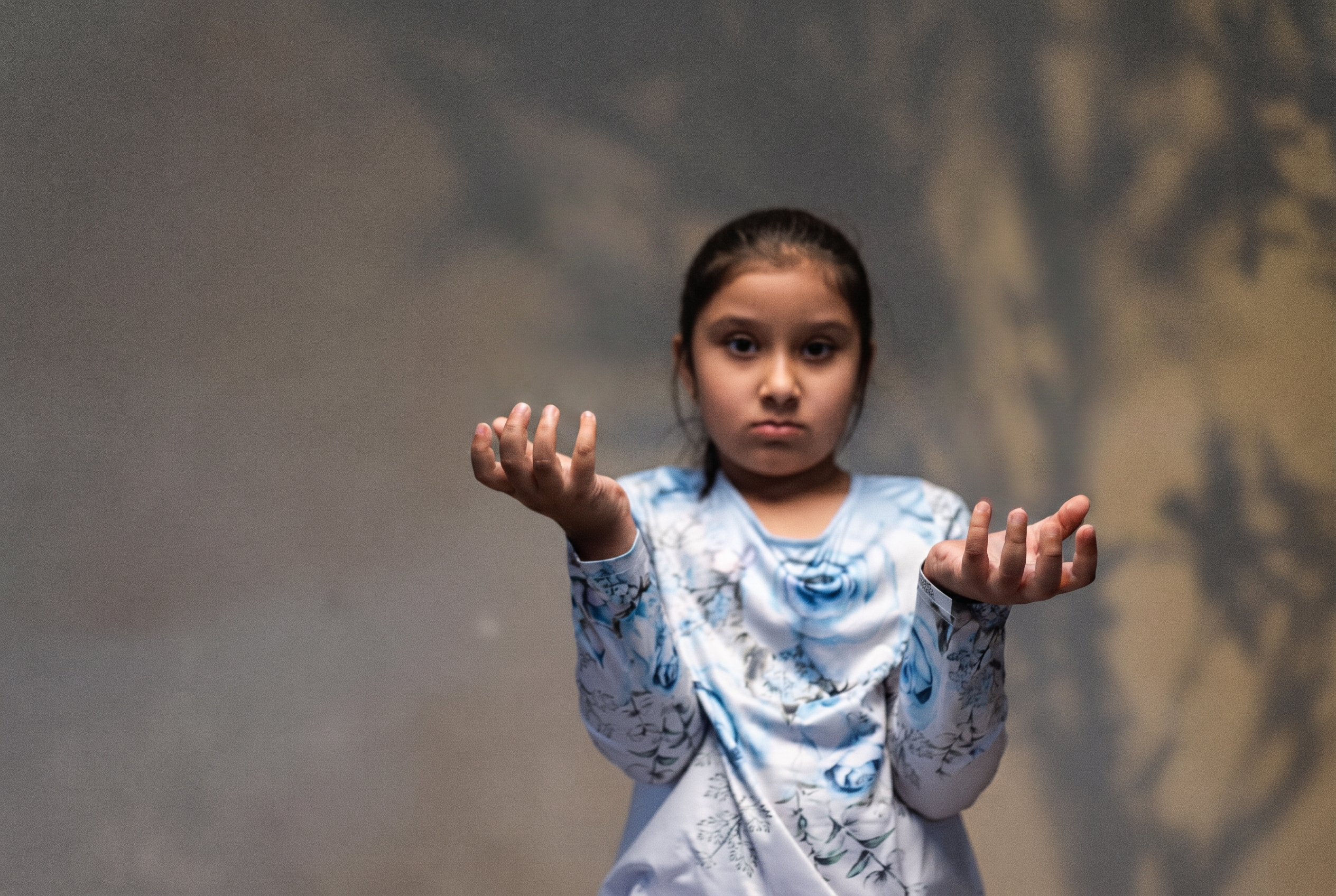 A young girl holding out both hands