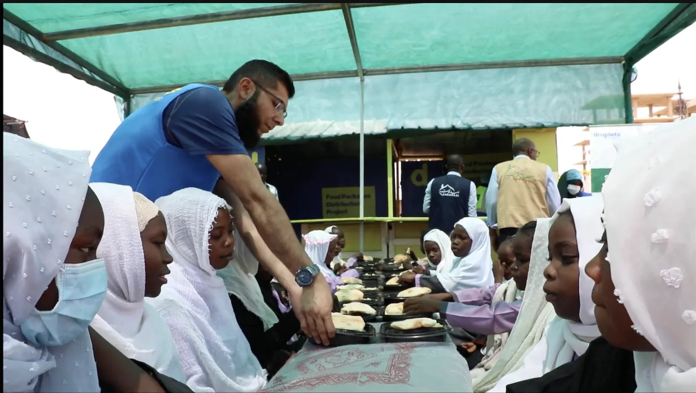 Droplets of Mercy team serving hot meals to children at a food distribution in Sudan